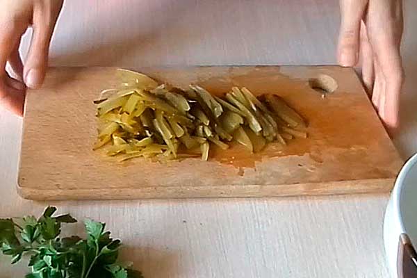 Салат приправим соленым огурцом, режем его средней соломкой
